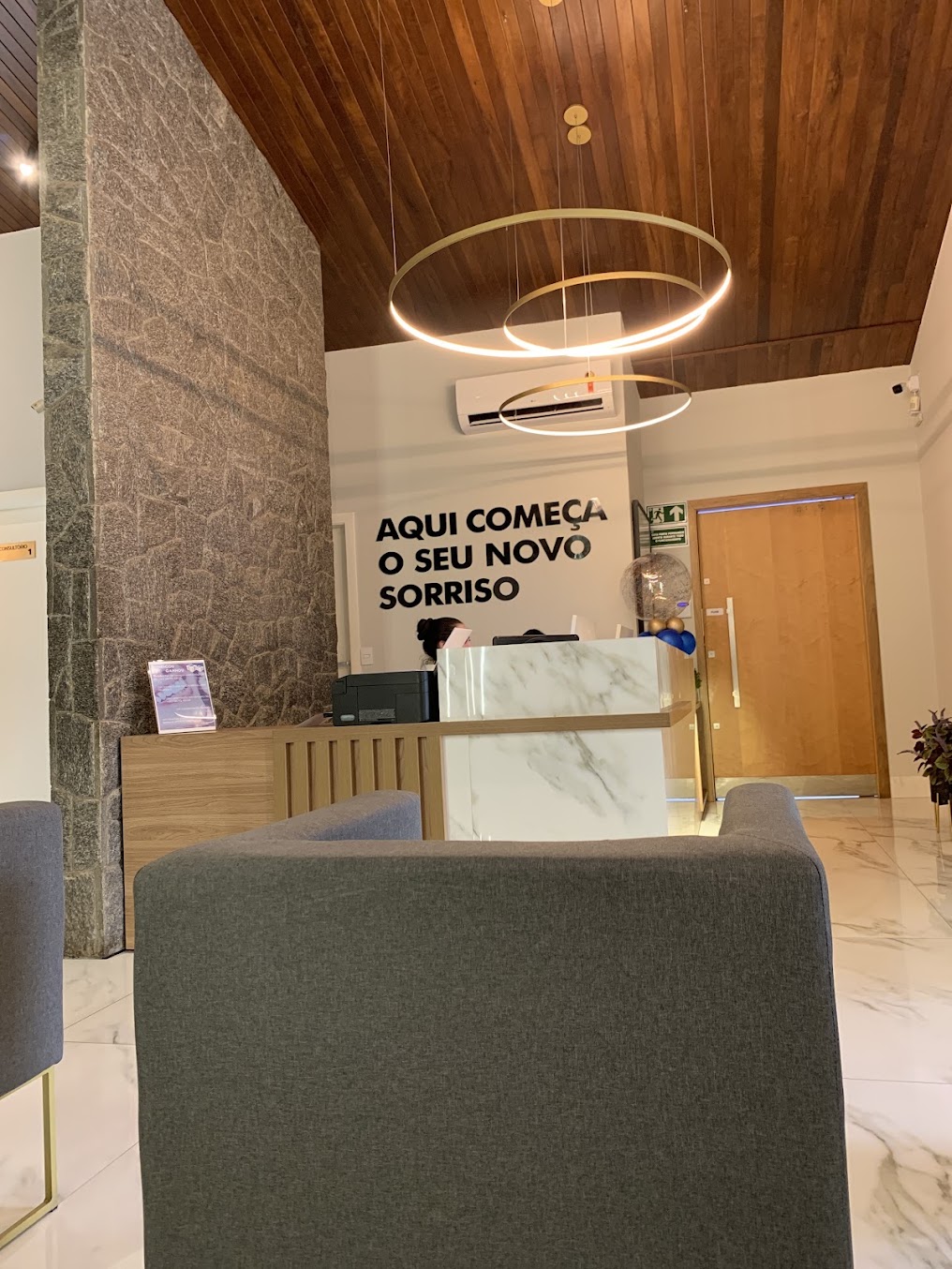 Recepção da Clínica Gathi com iluminação circular e balcão de atendimento